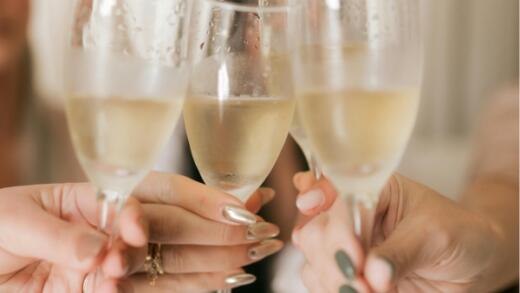a group of women cheering their prosecco glasses