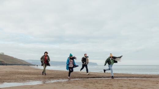 Group of friends wrapped up on a beach walk