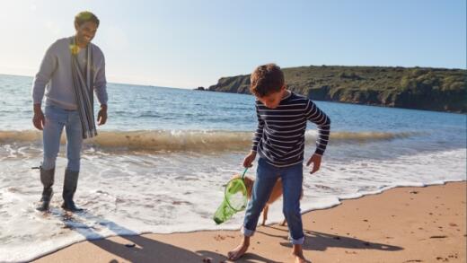 Father and son on the beach with their dog
