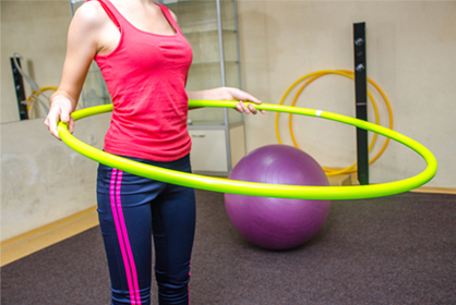 Woman in sportswear with hula-hoop 