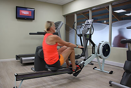 Lady on rowing machine in fitness suite at Hoburne Blue Anchor