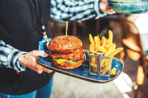 Waiter serving burger and fries 