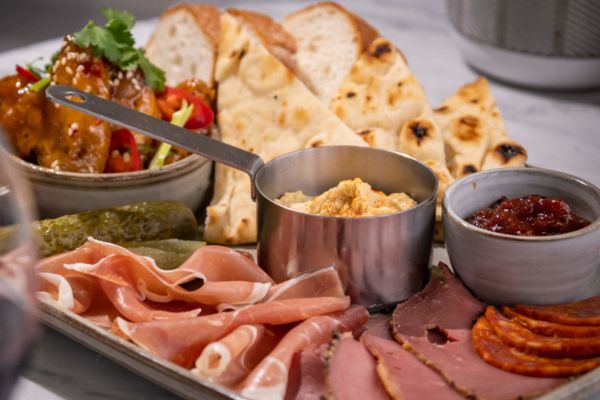 Mezze board with a selection deli meats, pita, dips