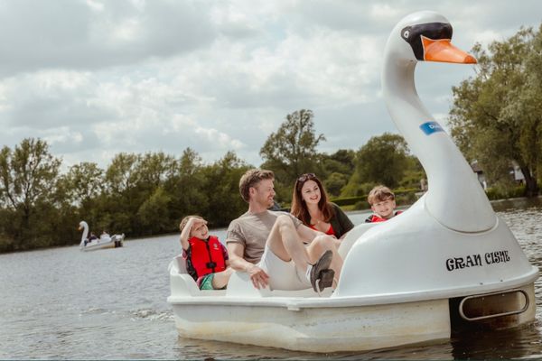 Family on a swan pedalo on the Cotswold Lake